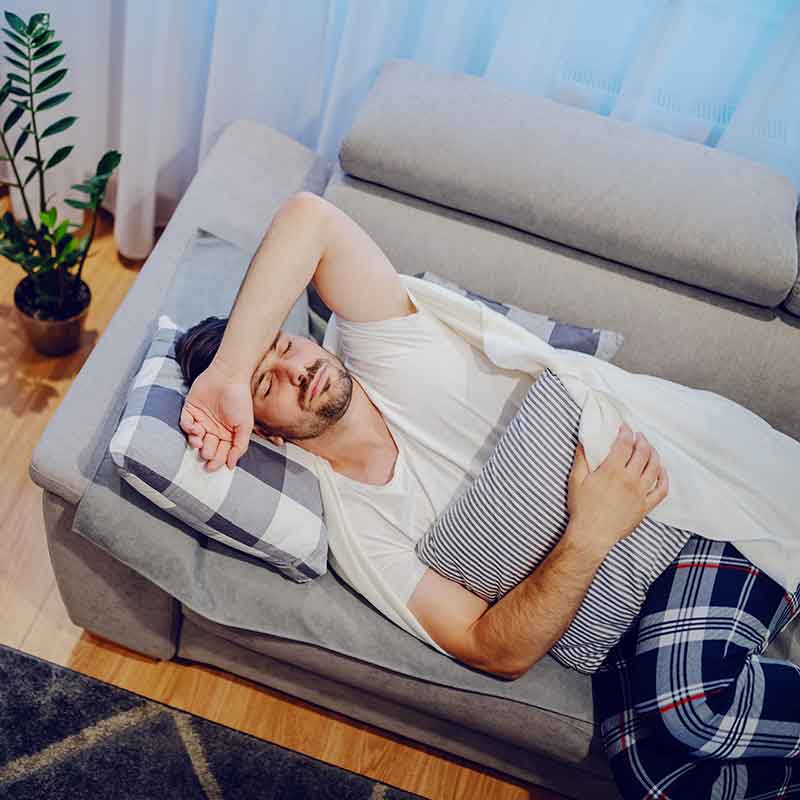 man sick sleeping on couch