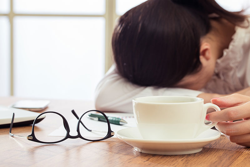 woman sitting at a desk tired