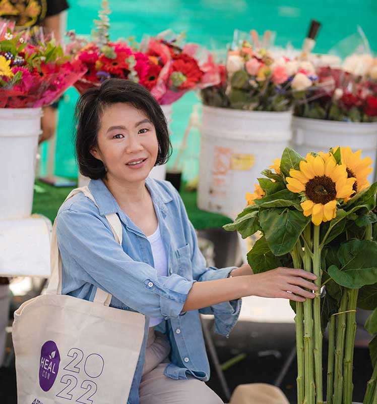 Xiaoyun holding flowers at the farmers market